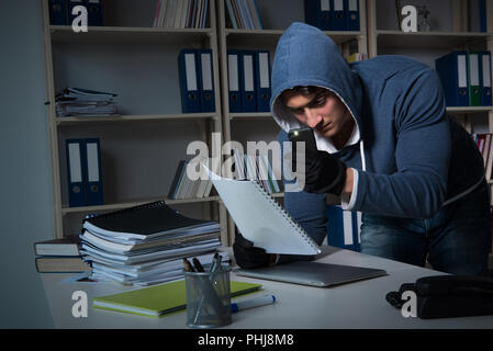 Giovane uomo in attività di spionaggio industriale concept Foto Stock