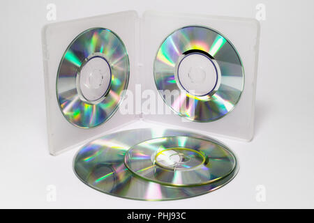 Caso per mini CD. Vassoi interni di fronte-retro in plastica semitrasparente box con dischi iridescente sui fermi e la pila di diversi formati di dischi Foto Stock