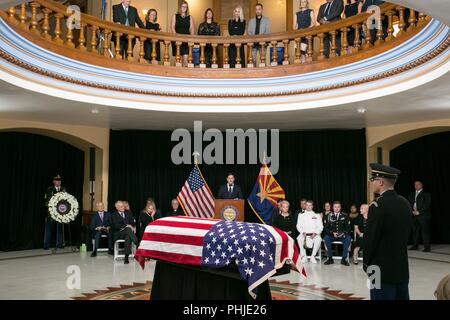 Arizona Gov. Doug Ducey offre un commento come bandiera drappeggiati scrigno di John McCain, stabilisce nello stato presso l'Arizona State Capitol Agosto 29, 2018 a Phoenix, in Arizona. L'ex senatore i resti giacciono in stato negli Stati Uniti Capitol Rotunda prima della sepoltura presso l'U.S. Accademia Navale. Foto Stock