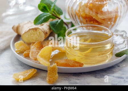 Il tè allo zenzero e fette di zenzero candito closeup. Foto Stock