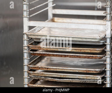 Rack foglio di tenuta padelle in una cucina commerciale Foto Stock