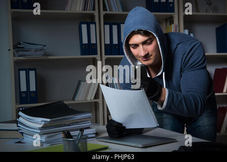 Giovane uomo in attività di spionaggio industriale concept Foto Stock