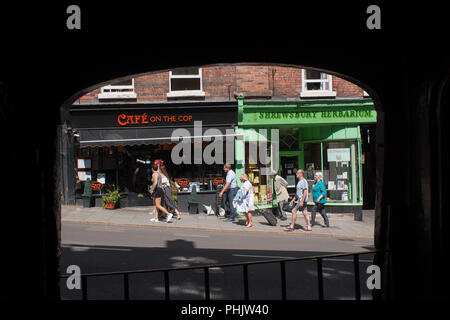 Vista che mostra due negozi indipendenti su Wyle Cop nel centro di Shrewsbury, Shropshire, 2016. Alcune persone sono passato a piedi i negozi. Foto Stock