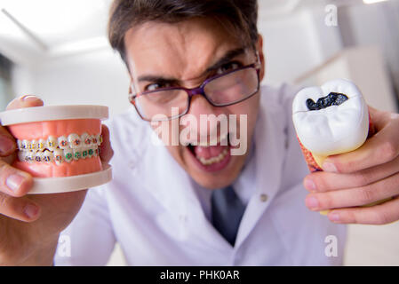 Funny dentista con denti modello in ospedale Foto Stock