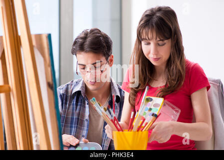 Artista il coaching studente nella classe di pittura in studio Foto Stock