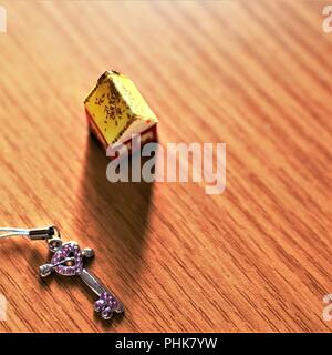 Una piccola casa rurale e un tasto giacciono su una tavola di legno Foto Stock