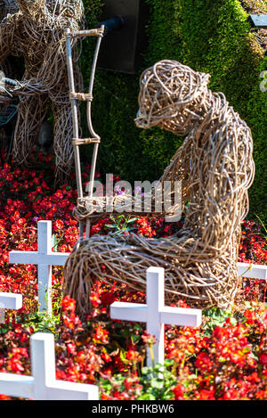 Prima Guerra Mondiale ricordo centenario giardino memorial a Colchester Castle Park, Colchester, Essex, Regno Unito. Grande Guerra willow figura. Croci. Fiori Foto Stock