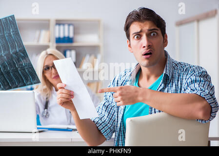 Paziente maschio arrabbiato con costosi healthcare bill Foto Stock