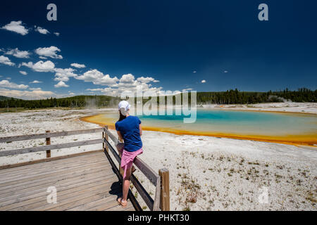 La donna si affaccia turistico termale a Yellowstone Foto Stock