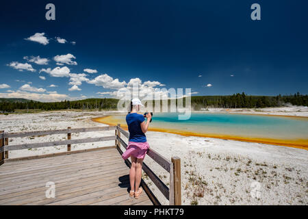 La donna si affaccia turistico termale a Yellowstone Foto Stock