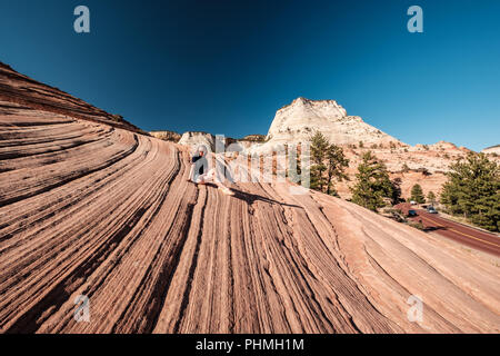 Donna seduta sulla formazione di roccia in Utah, Stati Uniti d'America Foto Stock