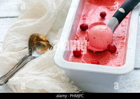 Gelato al mirtillo e un cucchiaio in un contenitore metallico. Foto Stock