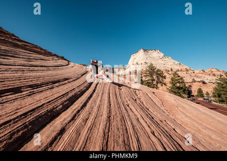 Donna seduta sulla formazione di roccia in Utah, Stati Uniti d'America Foto Stock