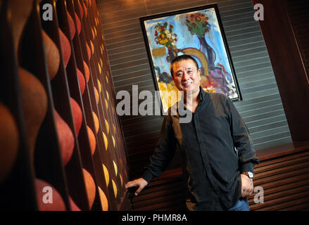 Lo chef Nobu Matsuhisa pone di fronte ad una pittura dal padre del suo business partner, attore americano Robert de Niro, al suo ristorante nel centro di Foto Stock