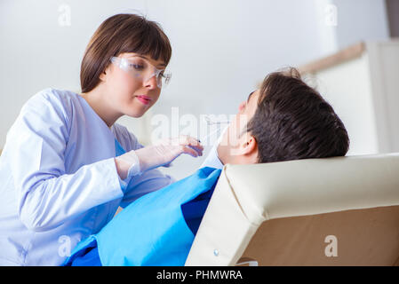 Donna dentista medico con il paziente di sesso maschile in ospedale Foto Stock