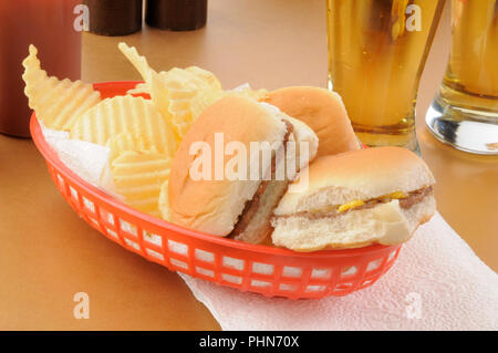 Mini cheeseburger con patate fritte in un cestello e birra Foto Stock