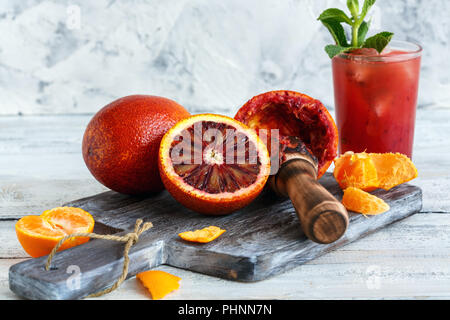 Un bicchiere di succo fresco di arance e un pezzo di arancia su un  tagliere. Succo d'arancia fresco con arance a fette Foto stock - Alamy