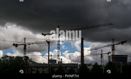 Gru a torre a lavorare sotto temporale in un quartiere in costruzione nella periferia della città di Tallinn, Estonia Foto Stock