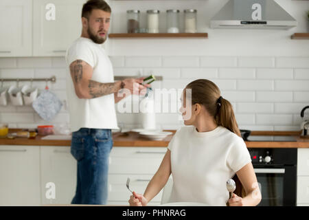 Mad donna scolding marito per la cattiva qualità per la cottura Foto Stock