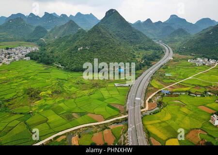 Pechino, Cina. Il 30 agosto, 2018. Foto aeree prese su agosto 30, 2018 mostra la superstrada Huixing threading attraverso i rilievi carsici in Zhenfeng County, a sud-ovest della Cina di Guizhou. Guizhou ha costruito 5,833 chilometri di autostrada entro la fine del 2017. Credito: Liu Xu/Xinhua/Alamy Live News Foto Stock