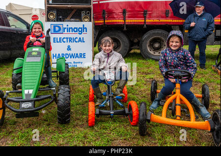 Bantry, West Cork, Irlanda. 2° settembre 2018. Bantry Agricultural Show si svolge presso la pista di atterraggio per aerei di Bantry oggi in terribili condizioni meteorologiche. Nella foto il divertimento sul go kart sono: Gracie Connor, Kealkil di età compresa tra i 8; Orla O'Connor, Kealkil di età compresa tra i 5 e Anna O'Sullivan, Coomhola di età compresa tra i 8. Credito: Andy Gibson/Alamy Live News Foto Stock