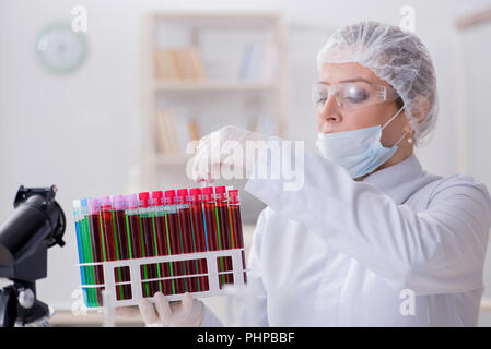 Donna medico verifica di campioni di sangue in laboratorio Foto Stock