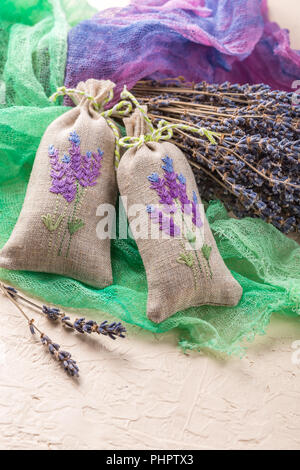 Mazzo di fiori di lavanda ed i sacchetti riempiti con lavanda essiccata. Foto Stock