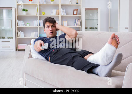 Uomo con gamba rotta recuperando a casa Foto Stock