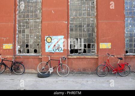 Lo stile tradizionale di biciclette di fronte abbandonato coperto di graffiti edificio in fabbrica con le finestre rotte Foto Stock