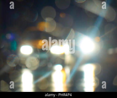 Di un bianco luminoso luci dalle vetture nella notte city street sfocato sfondo astratto Foto Stock