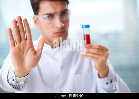 L'uomo medico verifica di campioni di sangue in laboratorio Foto Stock