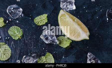 Ingredienti per rendere estate limonata mojito su uno sfondo scuro. Foto Stock