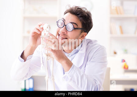 Crazy medico studiando scheletro umano Foto Stock