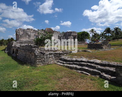 Sito archeologico e antiche rovine di stony tempio Maya a Tulum a Città del Messico sul campo erboso Foto Stock