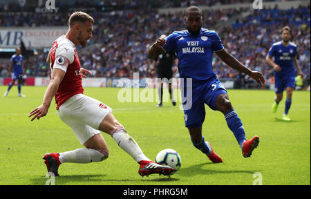 Dell'Arsenal Aaron Ramsey (sinistra) e Cardiff City's Junior Hoilett battaglia per la palla durante il match di Premier League al Cardiff City Stadium. Foto Stock