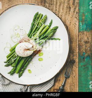 Asparagi verdi con soft-uovo sodo con piastra bianca, quadrato ritaglia Foto Stock