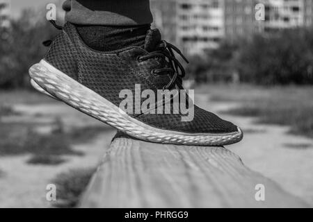 Un adolescente Tiptoes su una tavola di legno trave equilibratrice pronto al grande salto presso la Scuola di Formazione in cantiere un giorno d'estate. Copia dello spazio. Foto Stock