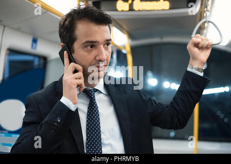 Ritratto di imprenditore parlando sul suo telefono cellulare mentre sta andando al lavoro