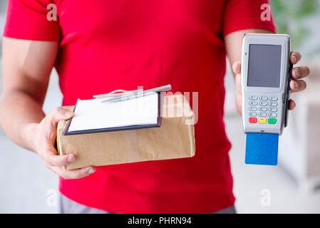 La consegna di pacchi essendo pagato con pos e carta di credito Foto Stock