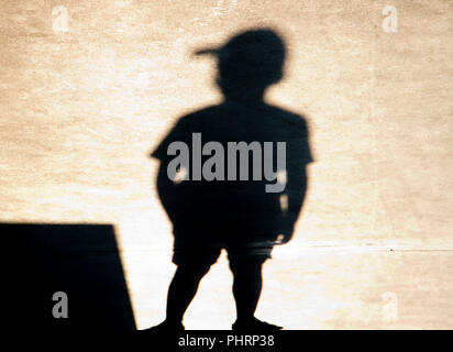 Ombra silhouette di un ragazzo con un cappuccio in piedi da solo Foto Stock