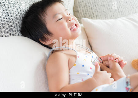 Medico di esaminare una bambina utilizzando uno stetoscopio. Medicina e cure sanitarie concetto. Foto Stock