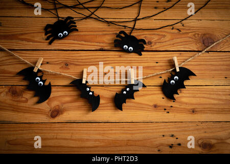 Artigianato di Halloween, bat spide e ragnatela su un tavolo di legno con sfondo happy Halloween testo. Il concetto di Halloween. Foto Stock