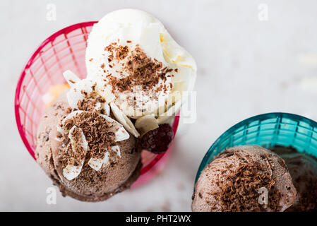 Plastica Gelato coni gelato con Cioccolato e gelato alla vaniglia scoop e bacche Foto Stock