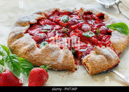 Tagliare torte fatte in casa con fragole e basilico. Foto Stock