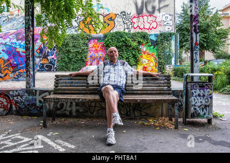 Berlino,angolo di graffiti, piccolo parco con alberi di betulla,panche, trampolino. Edifici circostanti, panchine e le pareti sono colorate tag graffiti Foto Stock