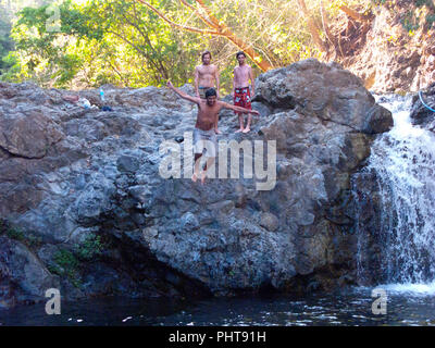 Kids jumping in corrispondenza di una cascata in Montezuma,Costa Rica Foto Stock