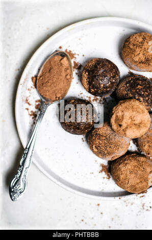 Il cioccolato alle nocciole morsi di energia laminati in cacao con sfondo bianco. Foto Stock