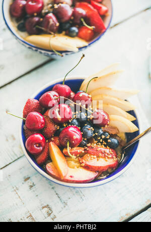 Una sana colazione ciotola frullato con frutta fresca e bacche, bee di polline e di miele sul tavolo blu sullo sfondo. Pulire mangiare, vegan, perdita di peso, alcalin Foto Stock