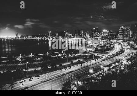 Skyline della città capitale Luanda e il suo mare durante la notte, Angola, Africa. Foto Stock