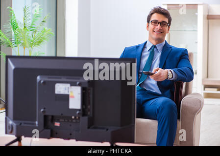 Businesman guardando la tv in ufficio Foto Stock